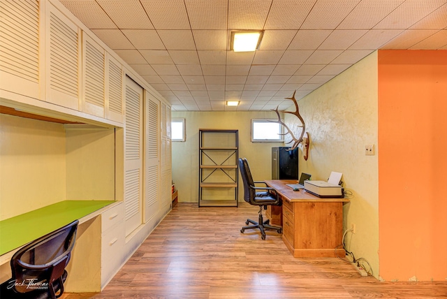 office space with a paneled ceiling and light wood-style floors