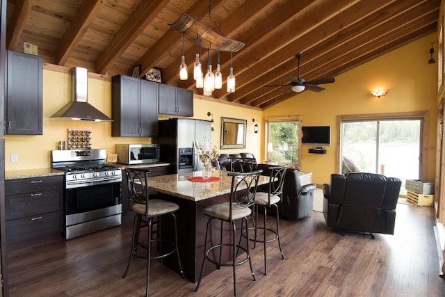 1226 Echo Lake Rd, Bigfork, MT 59911 - kitchen featuring appliances with stainless steel finishes, wall chimney range hood, a kitchen breakfast bar, open floor plan, and ceiling fan