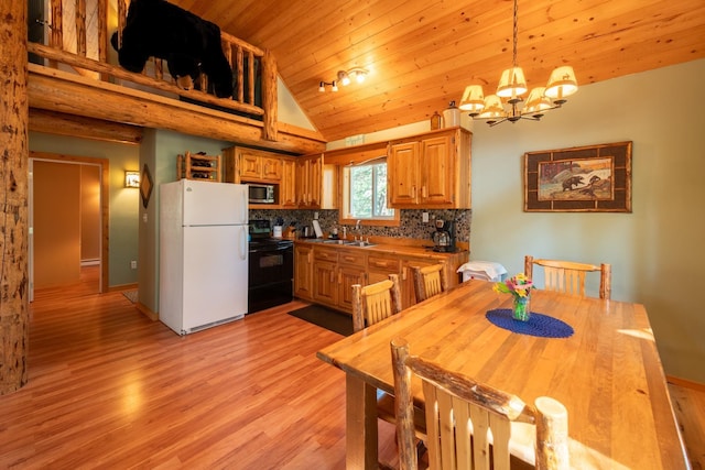 kitchen with hanging light fixtures, light hardwood / wood-style flooring, a notable chandelier, black / electric stove, and white fridge