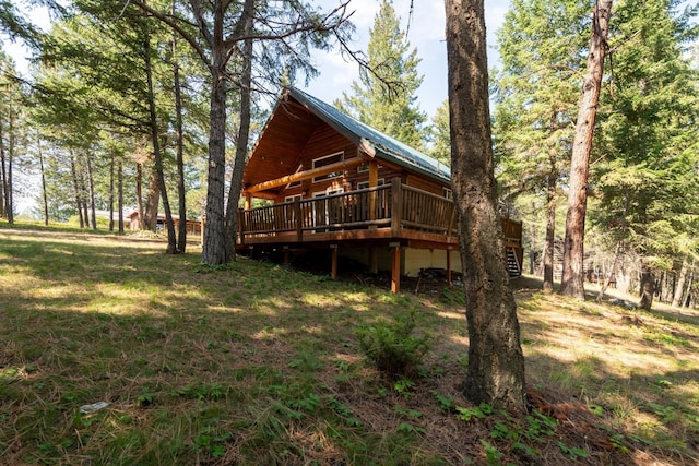 back of house featuring a deck and a lawn