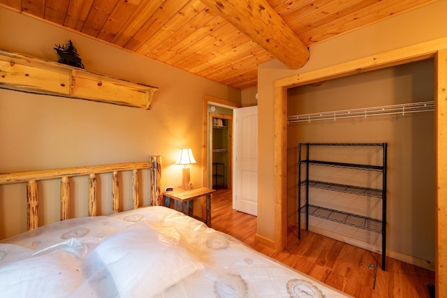 unfurnished bedroom with beamed ceiling, light wood-type flooring, a closet, and wooden ceiling