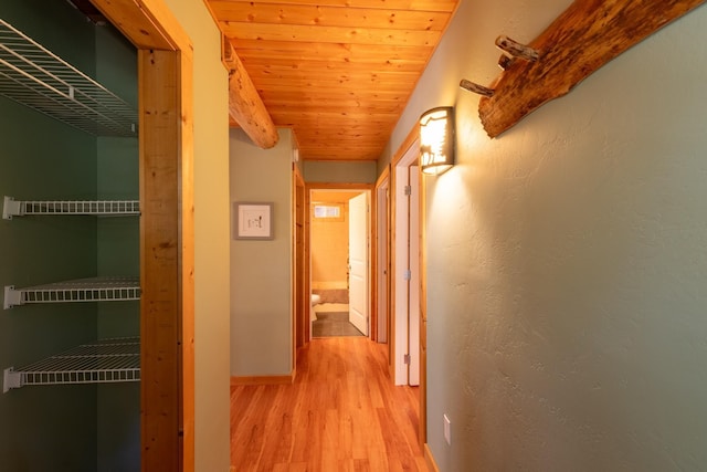 corridor with light hardwood / wood-style flooring and wood ceiling