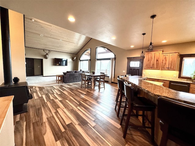 dining area with vaulted ceiling, sink, a wood stove, dark hardwood / wood-style flooring, and wooden ceiling