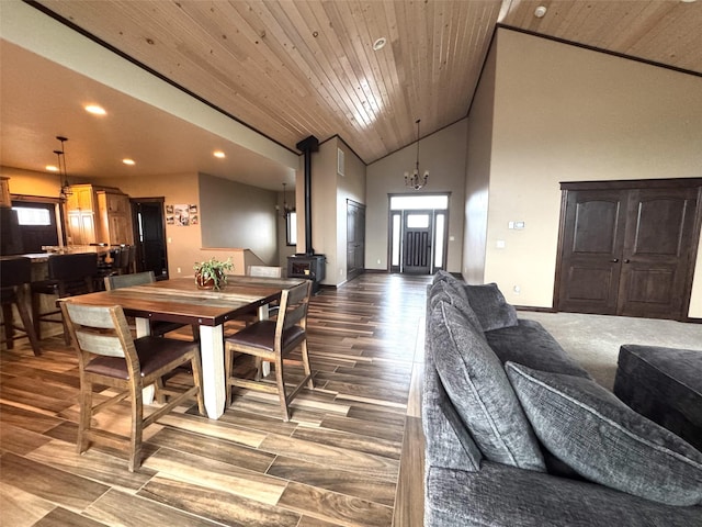 dining area with high vaulted ceiling, a wood stove, and wood ceiling