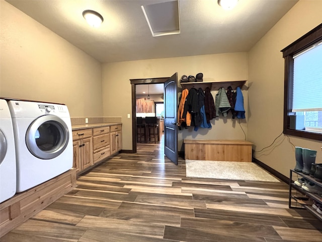 laundry area with washing machine and dryer, cabinets, and dark hardwood / wood-style floors