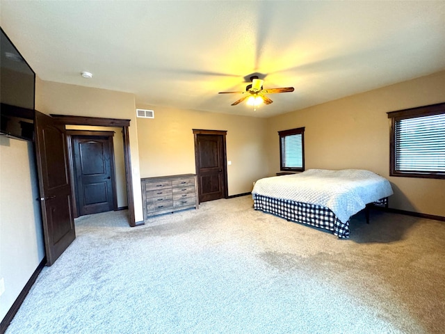 bedroom with ceiling fan and light colored carpet