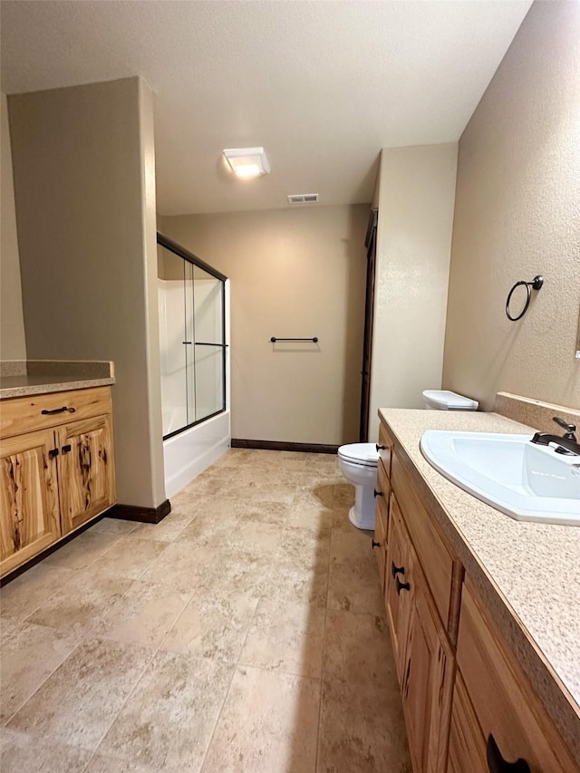 full bathroom featuring toilet, enclosed tub / shower combo, and vanity