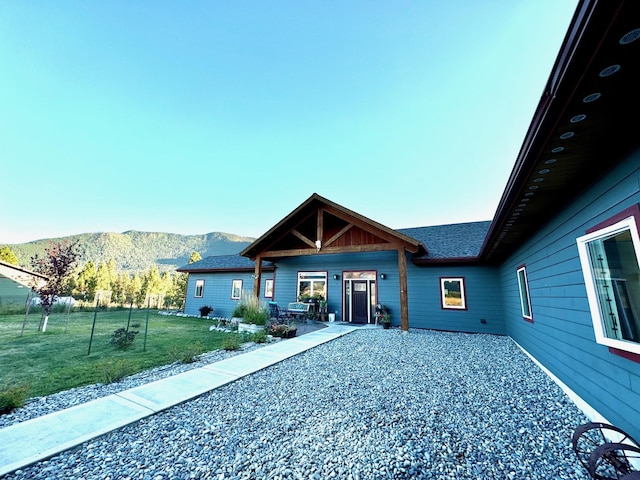 view of front of property with a mountain view and a front yard