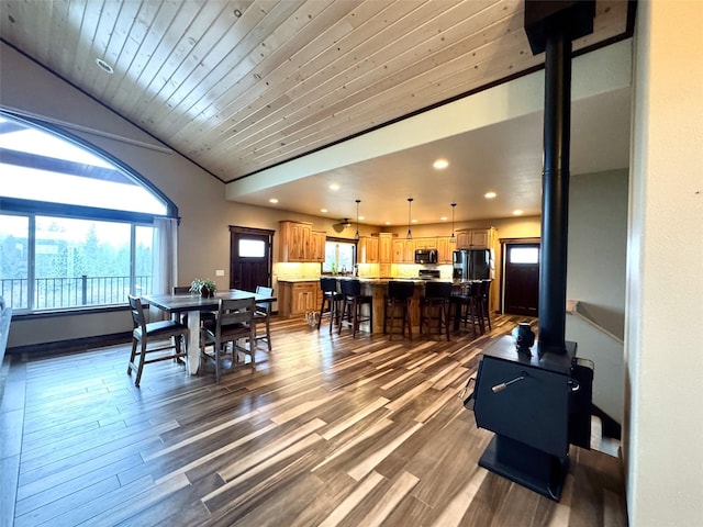 living room with lofted ceiling, wood ceiling, dark hardwood / wood-style flooring, and a wood stove