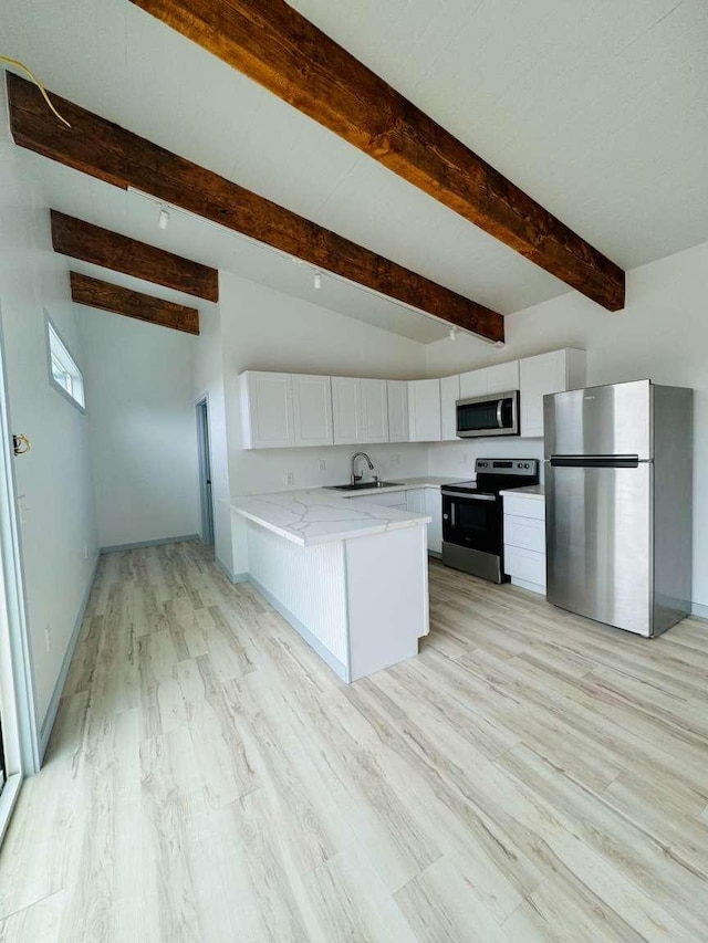 kitchen featuring kitchen peninsula, light wood-type flooring, stainless steel appliances, lofted ceiling with beams, and white cabinets