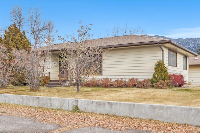 view of property exterior featuring a mountain view and a lawn