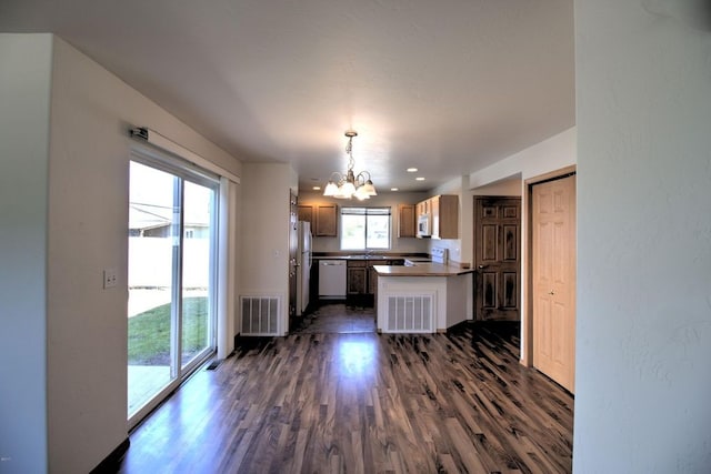 7AND9 Stratford Dr, Kalispell, MT 59901 - kitchen featuring white appliances, sink, pendant lighting, an inviting chandelier, and dark hardwood / wood-style floors