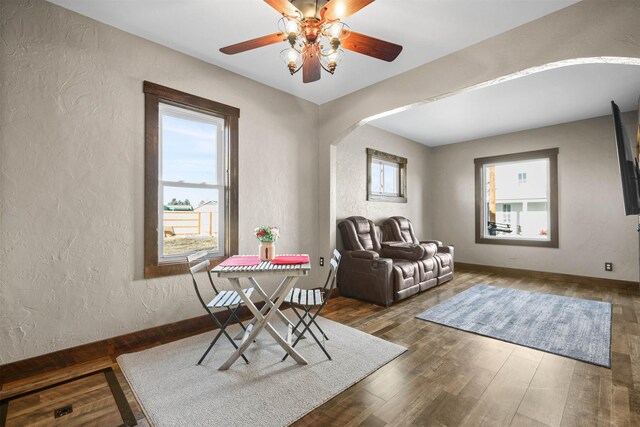 living area featuring dark hardwood / wood-style floors, ceiling fan, and a healthy amount of sunlight