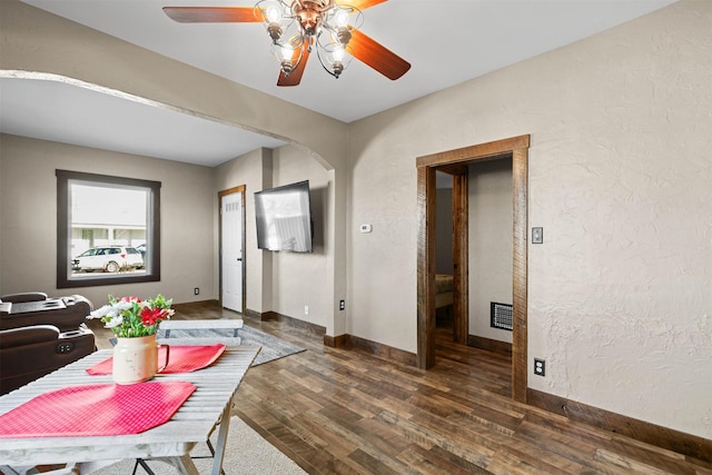 dining area with dark hardwood / wood-style floors, elevator, and ceiling fan