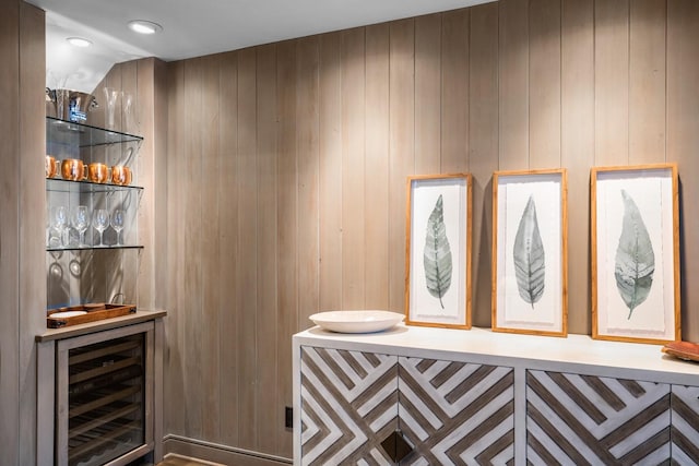 bar featuring wine cooler and wooden walls
