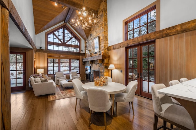 2120 Iron Horse Dr Unit 11, Whitefish, MT 59937 - dining area with a chandelier, high vaulted ceiling, french doors, a stone fireplace, and hardwood / wood-style flooring