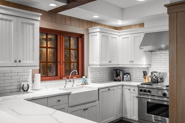 2120 Iron Horse Dr Unit 11, Whitefish, MT 59937 - kitchen with high end stove, exhaust hood, a sink, tasteful backsplash, and light stone countertops