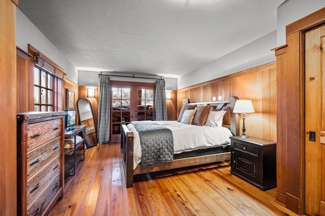2120 Iron Horse Dr Unit 11, Whitefish, MT 59937 - bedroom featuring french doors, hardwood / wood-style floors, and wood walls