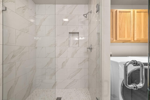 bathroom featuring washer / dryer and a shower with door