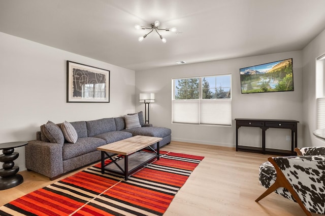 living room featuring wood-type flooring and a notable chandelier