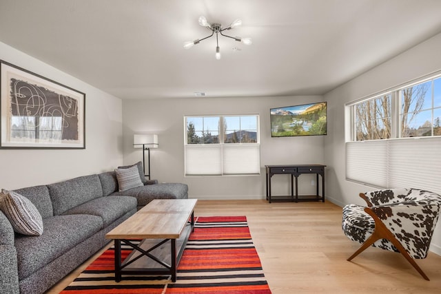 living room featuring light hardwood / wood-style flooring and a notable chandelier