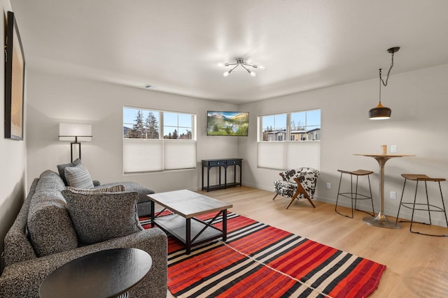 living room featuring light hardwood / wood-style floors, a wealth of natural light, and a notable chandelier