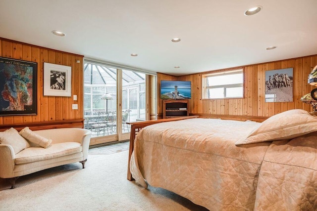 carpeted bedroom featuring access to outside and wooden walls