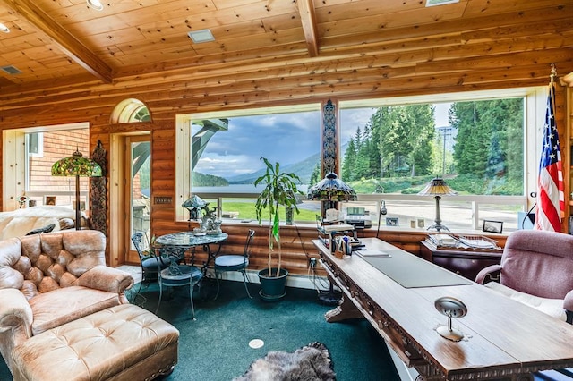 interior space with a healthy amount of sunlight, a mountain view, beamed ceiling, and wood ceiling