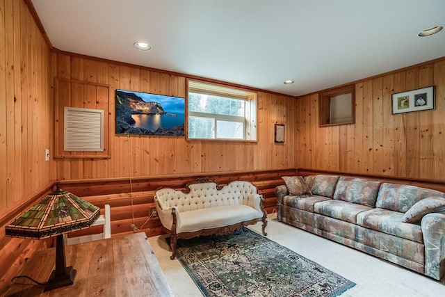 carpeted living room with wooden walls and ornamental molding