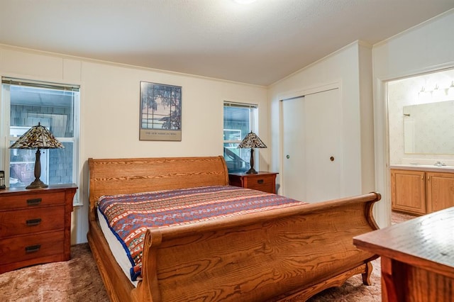 bedroom featuring connected bathroom, dark colored carpet, vaulted ceiling, a closet, and ornamental molding