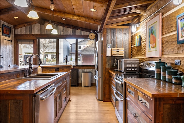 kitchen with butcher block counters, sink, wooden ceiling, pendant lighting, and stainless steel appliances