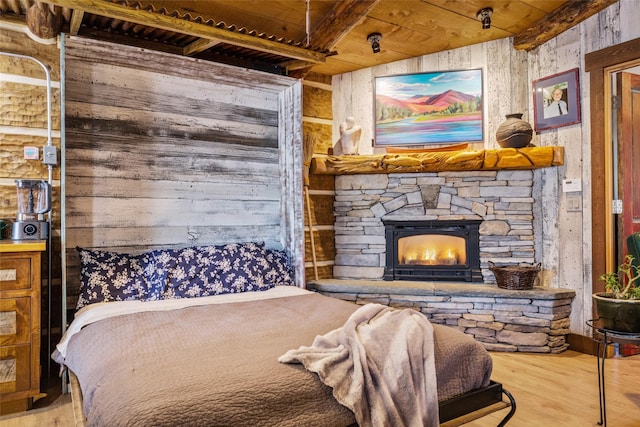 bedroom featuring hardwood / wood-style flooring, a fireplace, and wood ceiling