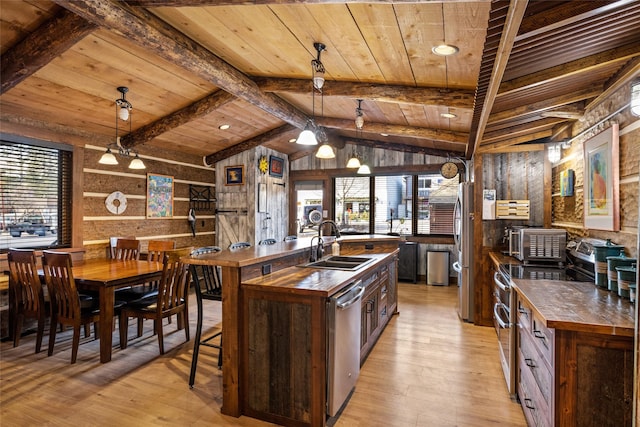 kitchen featuring hanging light fixtures, sink, wooden ceiling, and light hardwood / wood-style floors