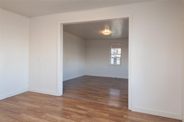 spare room featuring hardwood / wood-style floors and crown molding