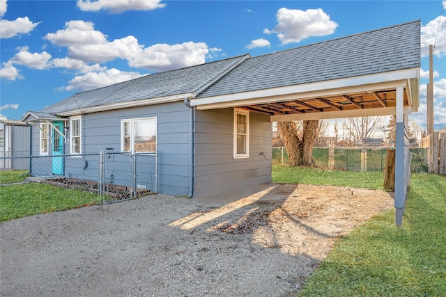 view of home's exterior with a carport and a lawn