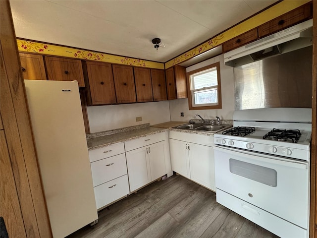 kitchen with dark hardwood / wood-style floors, white cabinetry, white appliances, and sink