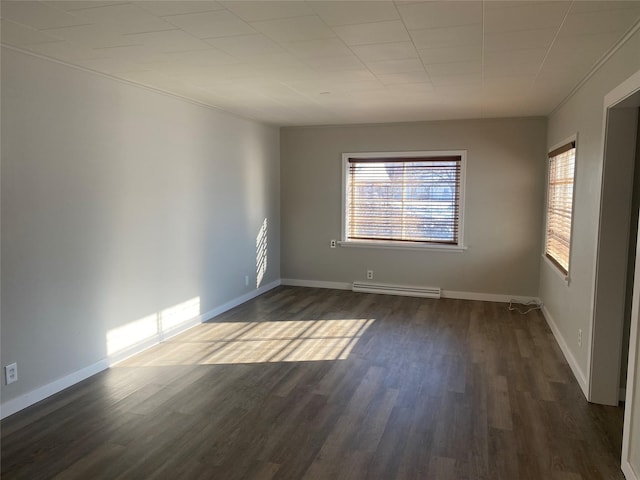 empty room featuring a baseboard heating unit and dark hardwood / wood-style floors