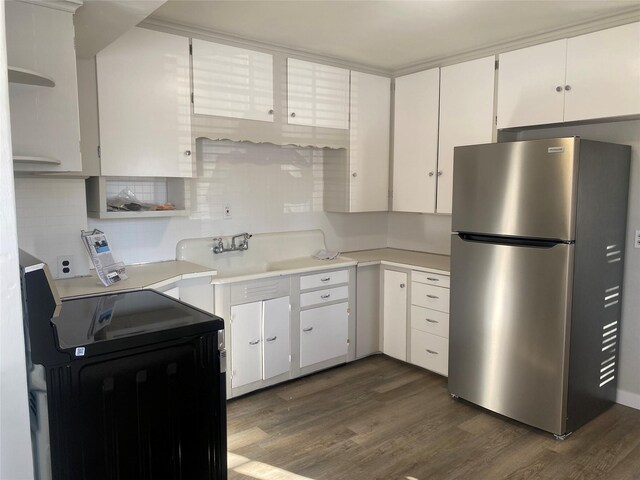 kitchen with white cabinets, stainless steel refrigerator, dark hardwood / wood-style flooring, and sink