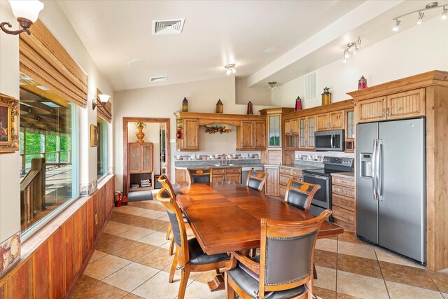 tiled dining space featuring wooden walls, plenty of natural light, and ceiling fan