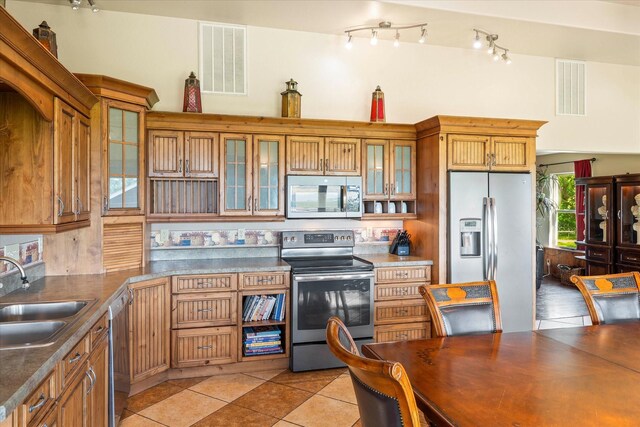 tiled dining room featuring lofted ceiling and sink