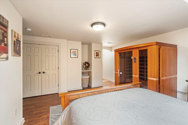 bedroom featuring a skylight and dark hardwood / wood-style flooring