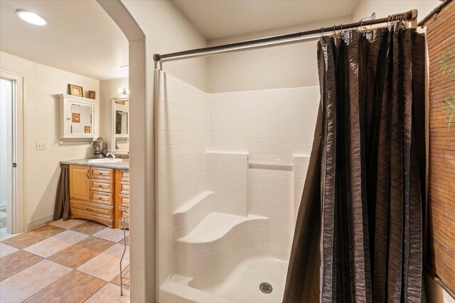 bathroom featuring tiled tub and vanity