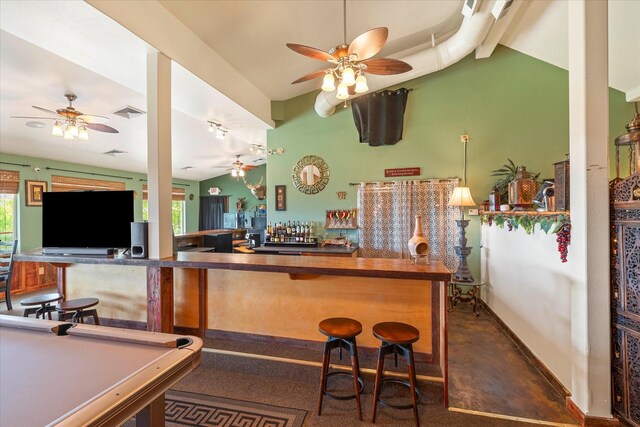 kitchen with kitchen peninsula, a breakfast bar, black fridge, and billiards