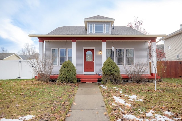 bungalow-style house featuring covered porch and a front lawn