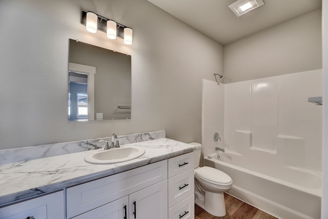 full bathroom with vanity, hardwood / wood-style flooring, toilet, and shower / bathtub combination