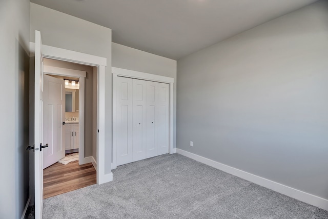 unfurnished bedroom with light colored carpet and a closet