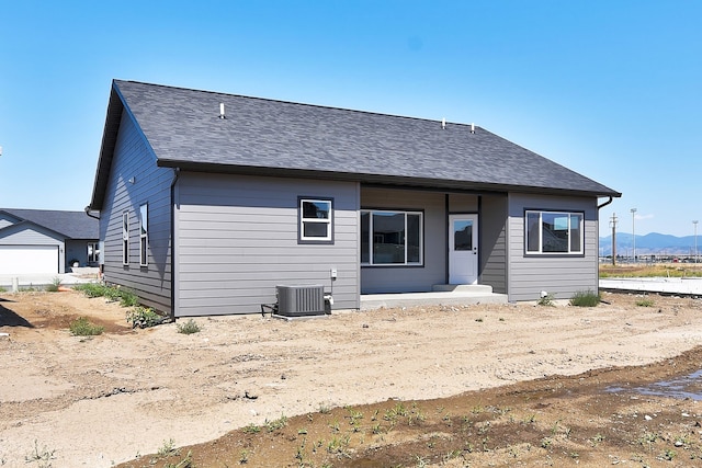 back of property featuring a mountain view and central AC