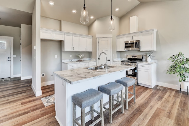 kitchen with white cabinetry, sink, an island with sink, and appliances with stainless steel finishes