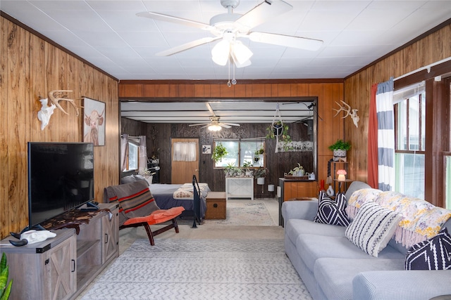 living area featuring wood walls and a ceiling fan