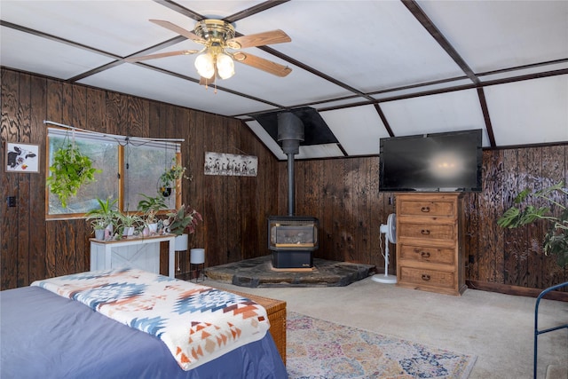 carpeted bedroom with a wood stove and wooden walls